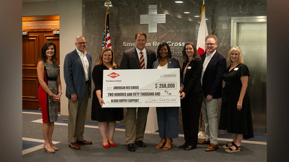 A group photo with Patrick Chrzanowski presenting a ceremonial check to the American Red Cross.