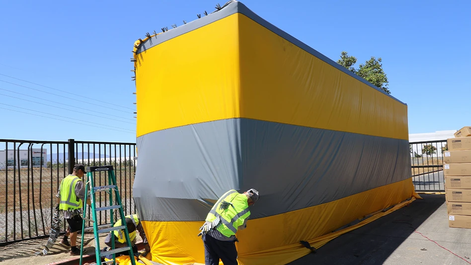 Technicians from Quality Pest Services tarp a shipping container as part of a fumigation following the discovery of Formosan subterranean termites.